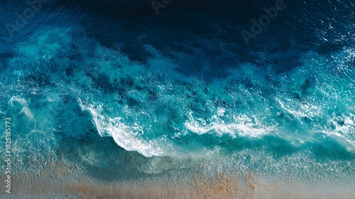 Aerial View of Turquoise Ocean Waves Crashing on Sandy Beach Shoreline with White Foamy Texture in Bright Sunlight