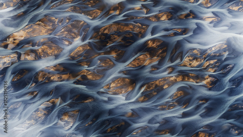 Aerial view of glacial rivers weaving through the rugged terrain, a tapestry of icy blues and earthy browns creating nature's abstract masterpiece, Hvolsvollur, Rangarbing eystra, Iceland.