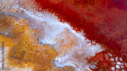 Aerial view of a surreal landscape of crimson and gold earth, interwoven with pale rivulets, creating an otherworldly texture from above, Ríotinto, Andalusia, Spain.