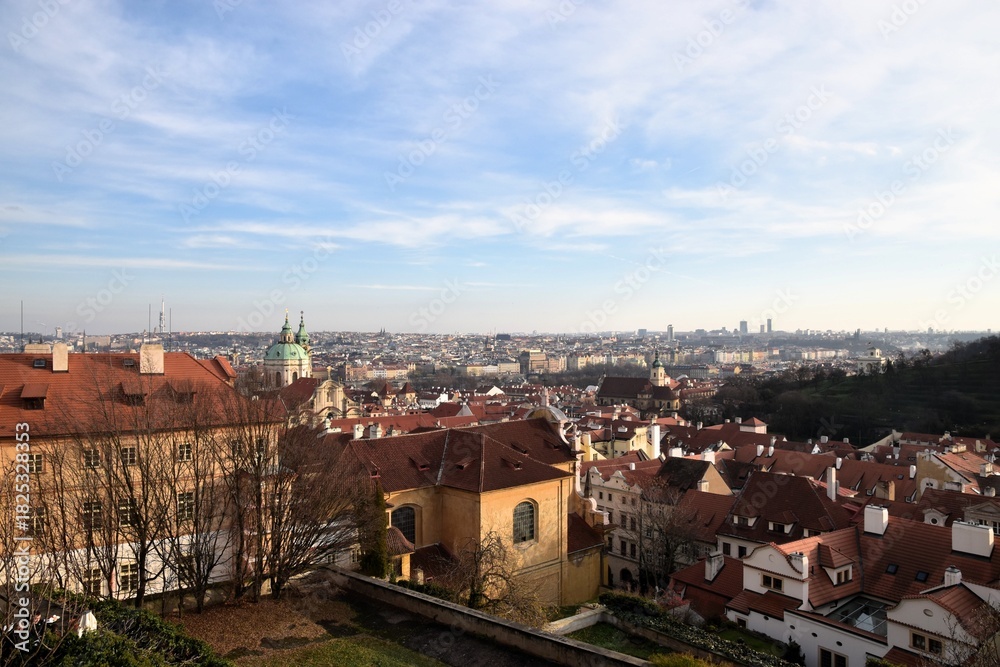 Fototapeta premium Scenic high-angle view of the medieval Old Town of Tallinn, Estonia, showcasing red tiled roofs, church spires, and historic architecture under a blue sky with clouds.