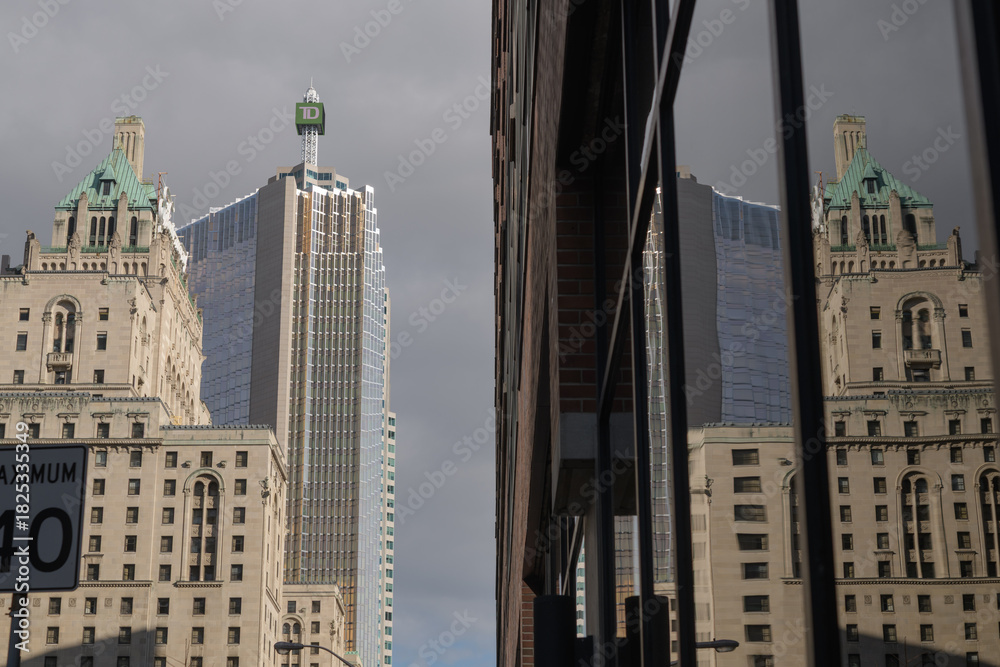 Fototapeta premium reflection of Fairmont Royal York, a five-star hotel, on a nearby office tower, looking east on Front St W, Toronto