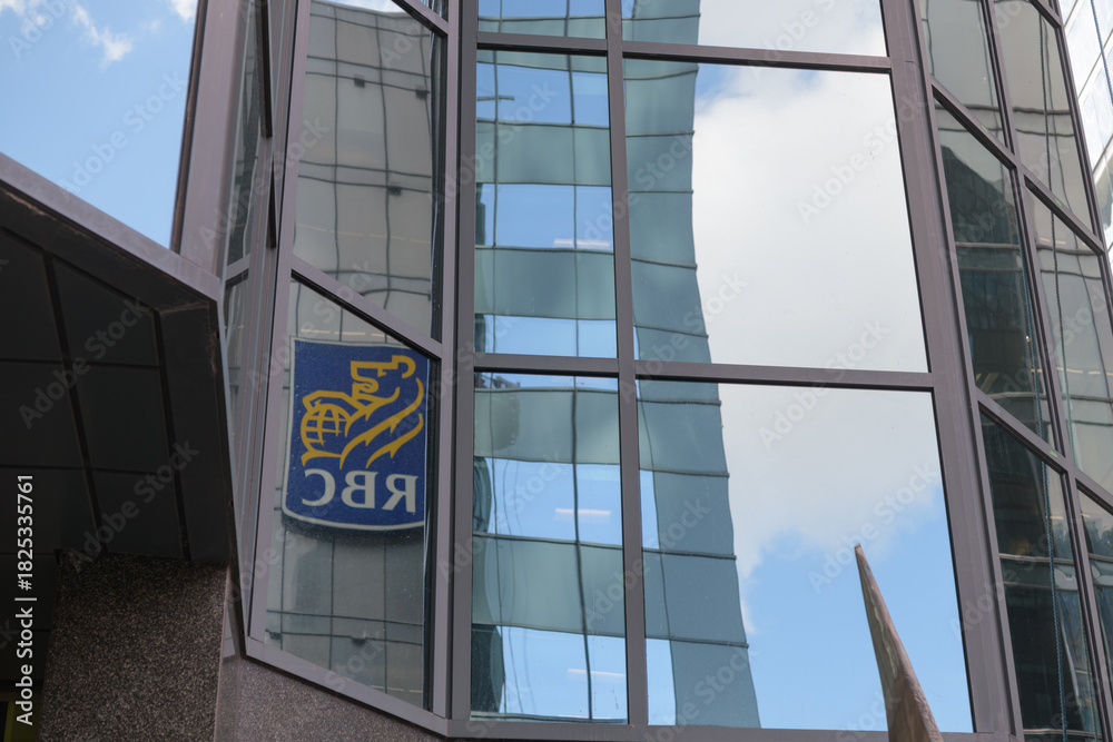 Obraz premium reflection of RBC (Royal Bank of Canada) corporate logo sign on a mirror glass window in downtown Toronto