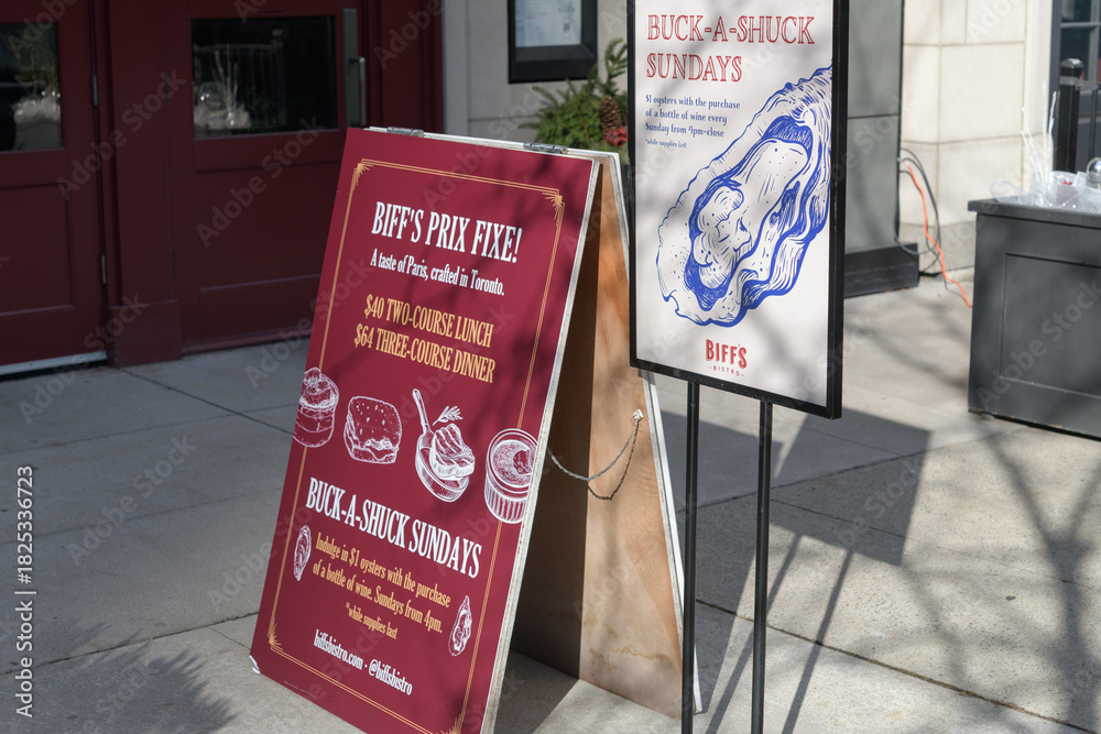 Fototapeta premium sidewalk signs outside Biff's Bistro, a restaurant, located at 2 Front St E, Toronto