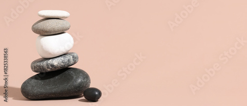 Canvas Print Stack of pebbles on beige background. Zen concept