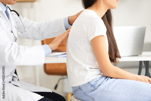 Male doctor checking postur...