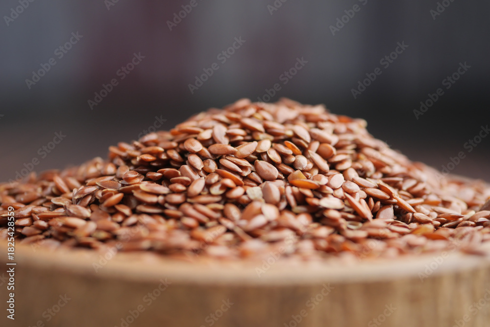 Obraz premium Brown flax seeds piled on a wooden surface