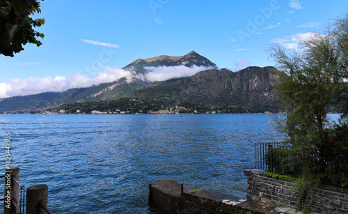 Beautiful view of mountain with clouds of Lake Como in Northern, Italy with boat dock nearby