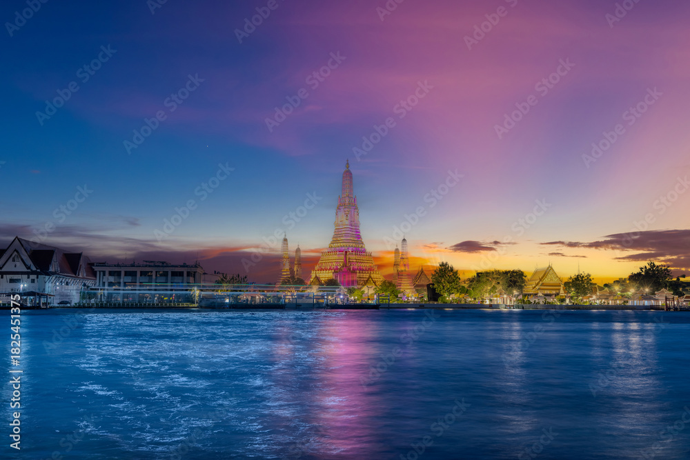 Fototapeta premium 26 November 2025 Beautiful Sunset colours of Thai Temple Wat Arun on Chao Phraya River in BKK Bangkok Thailand. The magic colourful neon light display on the temple at sunset is magical.