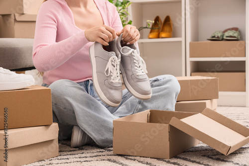 Woman putting grey sneakers...