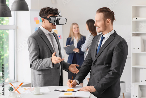 Young businessman using VR ...