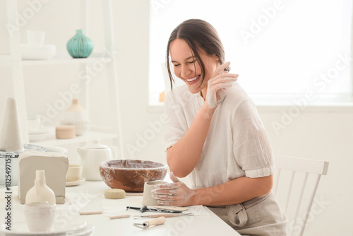 Young female potter shaping...