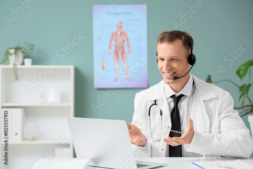 Young male doctor with lapt...