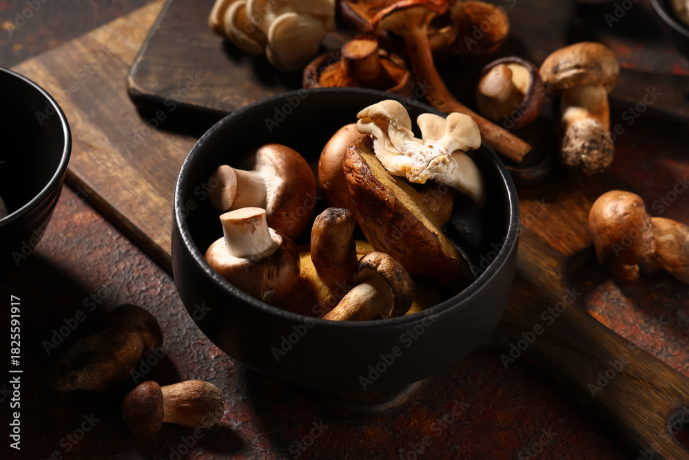 Fototapeta premium Bowl with different fresh mushrooms on red grunge background