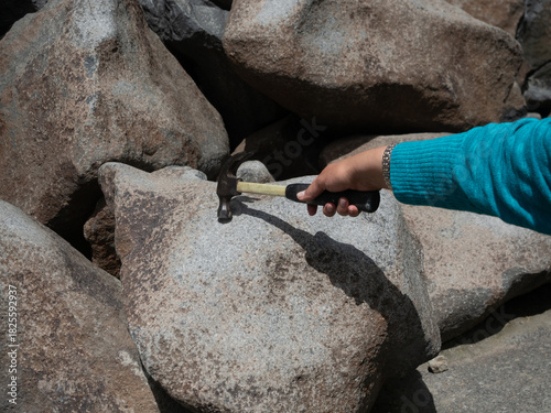 Woman Tapping a Hammer on a Ringing Rock in Montana
