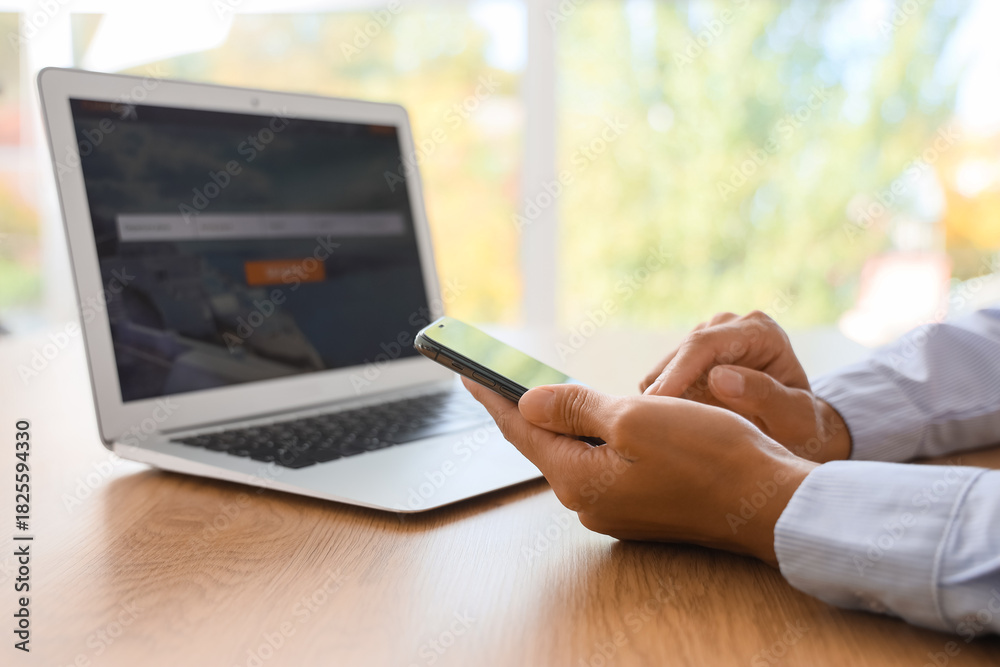 Naklejka premium Businesswoman's hands using mobile phone to search for tickets online in office, closeup