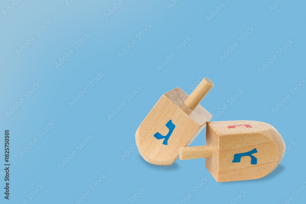 Fototapeta premium Wooden dreidels with blue and red symbols on a blue background