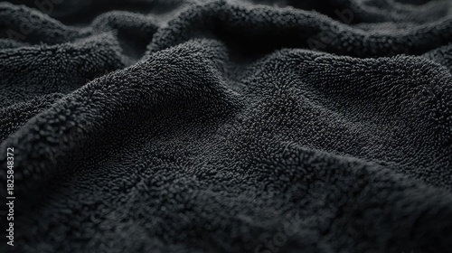 A close-up view of a black, fuzzy, and textured surface.