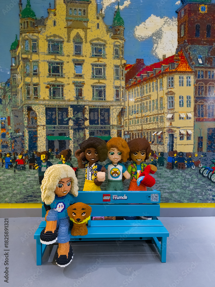 Obraz premium Copenhagen, Denmark - November 3, 2025: A bench with Lego Friends figurines at the showroom of the Lego store
