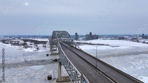 Cars crossing the Blatnik Bridge between Duluth, Minnesota and Superior, Wisconsin across Saint Louis Bay on a gray winter day - Aerial 4K drone video