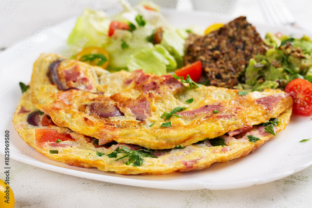 Naklejka premium Omelette with ham and vegetables. Healthy breakfast.