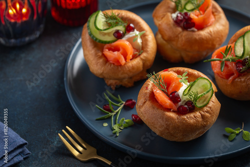 Yorkshire puddings with smoked salmon, cucumber and cream cheese, appetizers idea  for holiday dinner, blue background