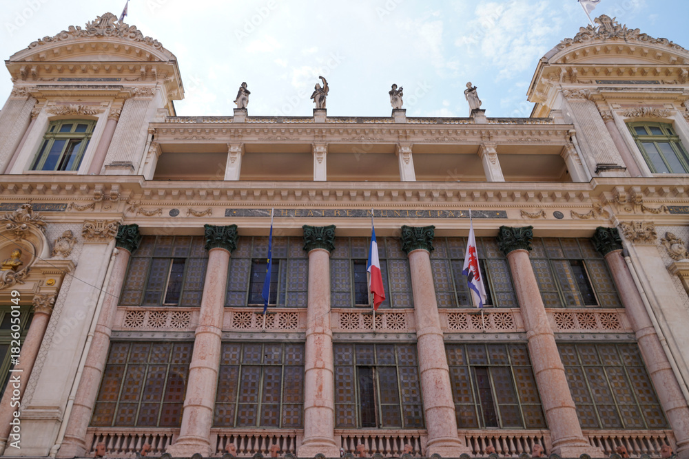 Obraz premium facade of the building of nice opera ornate european theater entrance with flags and columns