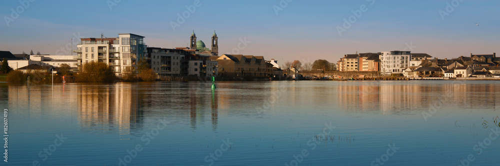 Fototapeta premium Athlone city skyline with landmark buildings reflected on the River Shannon at sunrise in County Westmeath, Ireland.
