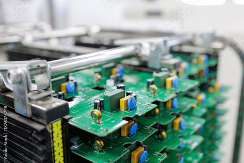 Stack of assembled printed circuit boards in rack at modern electronics factory