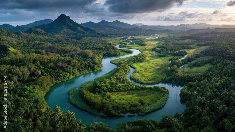 Obraz premium A winding river twists through a lush tropical valley, with green fields, dense forests, and distant mountains. Concept Tropical Valley Landscape, Winding River Scene, Lush Greenery, Dense Forests
