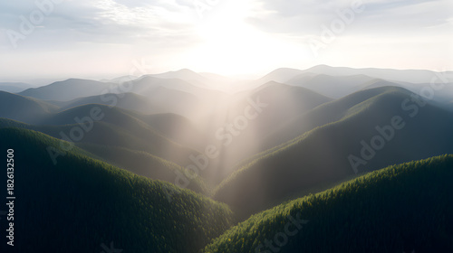 Mountain Valley Under Sunlight: Majestic mountain range with deep valleys, illuminated by the sun's radiant rays, creating a stunning display of natural grandeur.