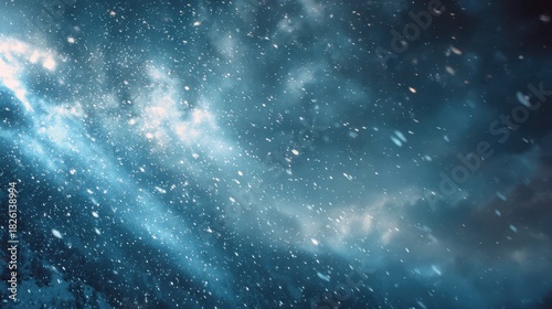 Falling snow against dark blue stormy sky with bright clouds winter