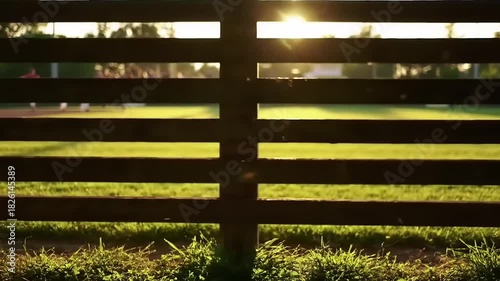 Wooden fence with field, and golden hour sunset.