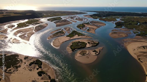 Aerial view of winding river estuary with lush greenery and sandy banks