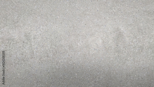 Close-up of a textured concrete surface with small embedded stones, showcasing a neutral gray industrial aesthetic.