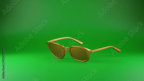 Gold-framed sunglasses with dark lenses angled on vibrant green background.