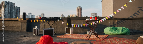 Specious rooftop with modern party decorations and DJ set, with city view on backdrop