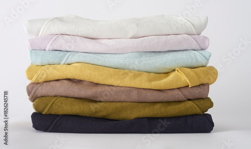 Foto Stacked pastel colored shirts and sweatshirts apparel laundry on white backgroun