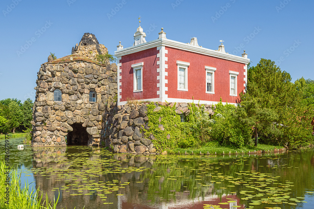 Obraz premium The stone island with the Villa Hamilton in Worlitz Park, in the middle of an English landscape garden