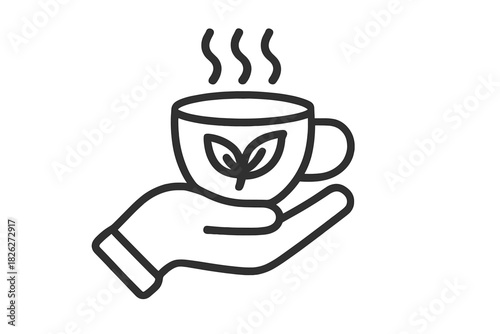 Hand holding a steaming cup of organic herbal tea with natural leaf design