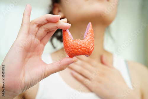 Hyperthyroidism, Overactive Thyroid, Thyroid Lymphoma, Asian woman with thyroid gland human anatomy model.