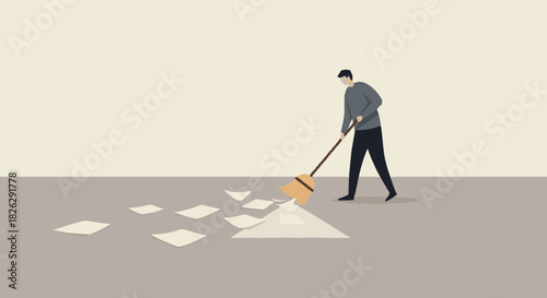 Man with a broom sweeping up scattered paper documents from the floor.