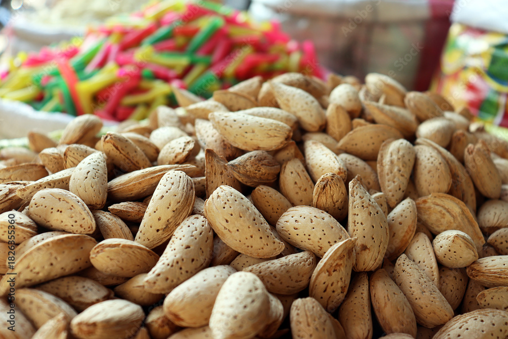 Obraz premium Whole almonds in shells market display close up