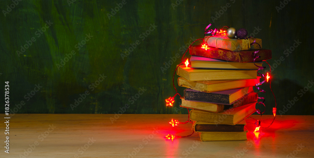 Fototapeta premium giving books for christmas,christmas gift,present,reading,literature,education, christmas,holiday concept with heap of books, christmas lights and decoration