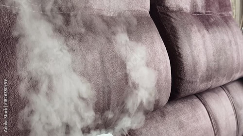 Cleaning upholstery in a living room using a steam cleaner for deep dirt removal