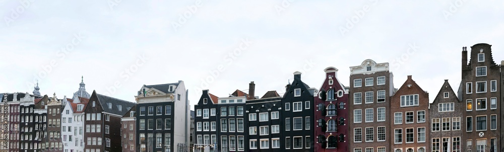 Fototapeta premium Vibrant photograph of the colorful houses along the canals in Amsterdam's Reederijplas area. The image captures the unique charm and character of Amsterdam's canals,