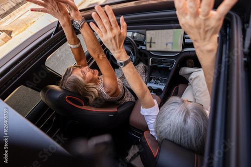 Senior couple enjoying car road trip with open sunroof