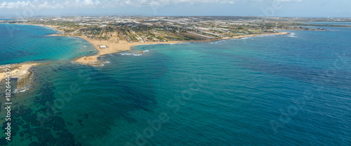Fototapeta Naklejka Na Ścianę i Meble -  Aerial view of the Sicilian coast. There is a long sandy beach overlooking the Mediterranean Sea. It is located in the municipality of Portopalo, in the province of Syracuse, Sicily, Italy.
