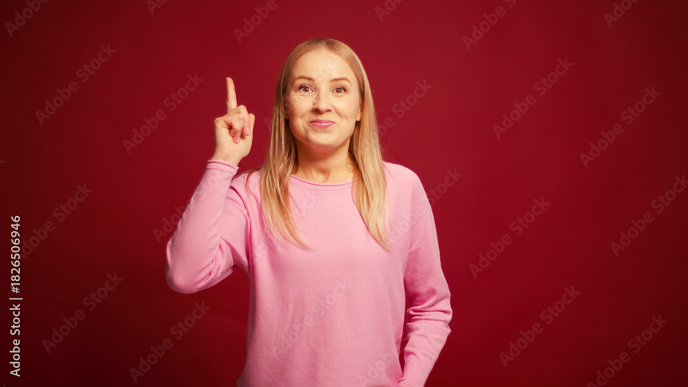 Fototapeta premium Pensive worry blonde woman thinking and worry looking away isolated on red background