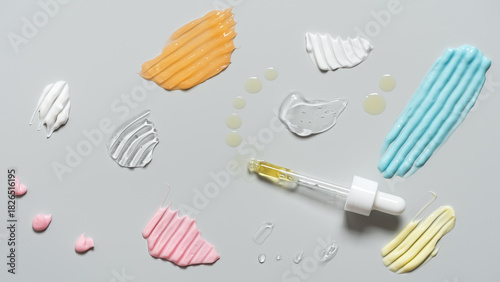 Samples of cosmetic products on gray background, cream, gel, serum, oil, top view, flat lay