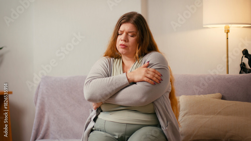 Plus size woman crosses arms and exhales showing nervousness